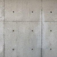 セパ穴が規則正しく並ぶコンクリート打ちっぱなしの外壁の写真