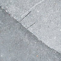 アスファルト舗装の継ぎ目と切れ目が交差するテクスチャの写真