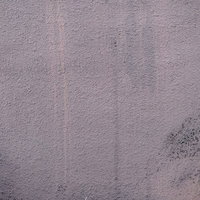 経年劣化した黒ずんだモルタル壁のテクスチャーの写真