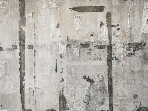 コンクリート外壁に残るシール跡とポスター跡