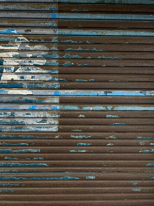 消えかけた庵のシャッター、錆と劣化のテクスチャー