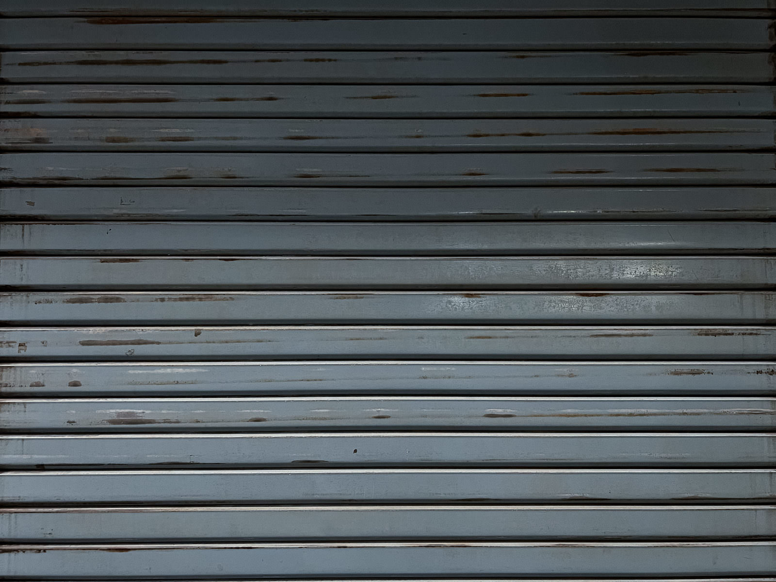 横縞模様が規則正しく並んだグレーの金属製シャッター