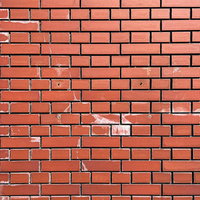 補修跡が残る赤茶色のレンガ壁のテクスチャーの写真