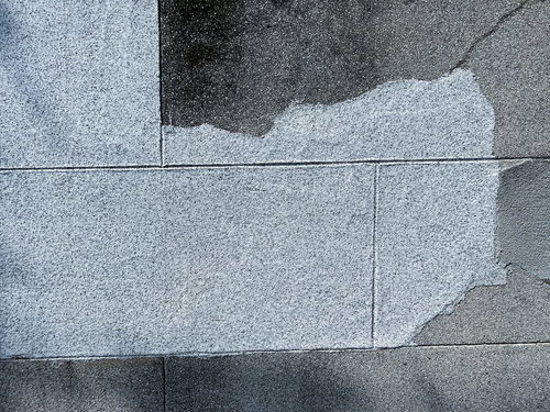 塗り直されたグレーのコンクリート塀のテクスチャー