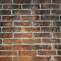 黒く汚れたレンガ壁のテクスチャー、経年劣化が見える古い煉瓦壁の写真