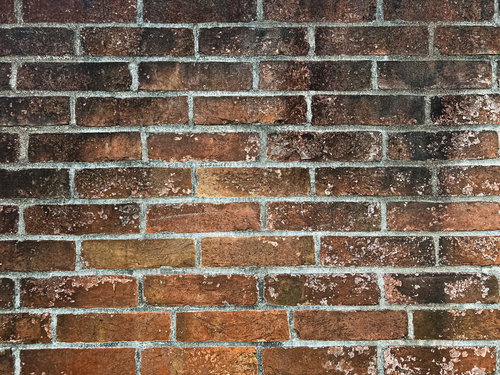 黒く汚れたレンガ壁のテクスチャー、経年劣化が見える古い煉瓦壁