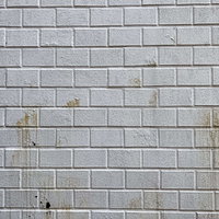 茶色い汚れが付いた灰色のレンガ調壁面のテクスチャーの写真