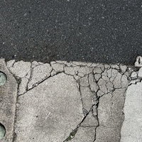 アスファルト道路に引かれたひび割れた白線のテクスチャーの写真