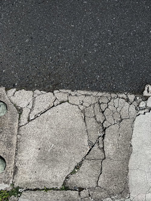 アスファルト道路に引かれたひび割れた白線のテクスチャー