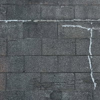 ひび割れを補修したグレーのブロック塀のテクスチャーの写真