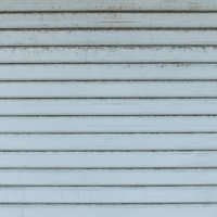 経年劣化で汚れた金属製シャッターの古い外壁の写真