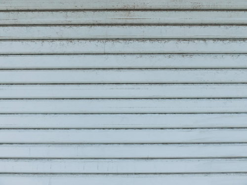 経年劣化で汚れた金属製シャッターの古い外壁