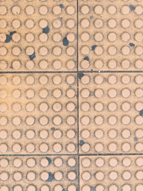 汚れた点状警告ブロックのテクスチャー表面