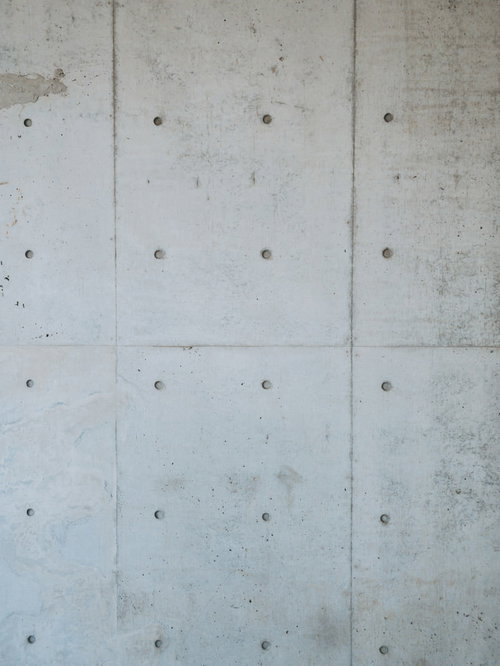 規則的な円形の穴が並ぶコンクリートむき出しの壁