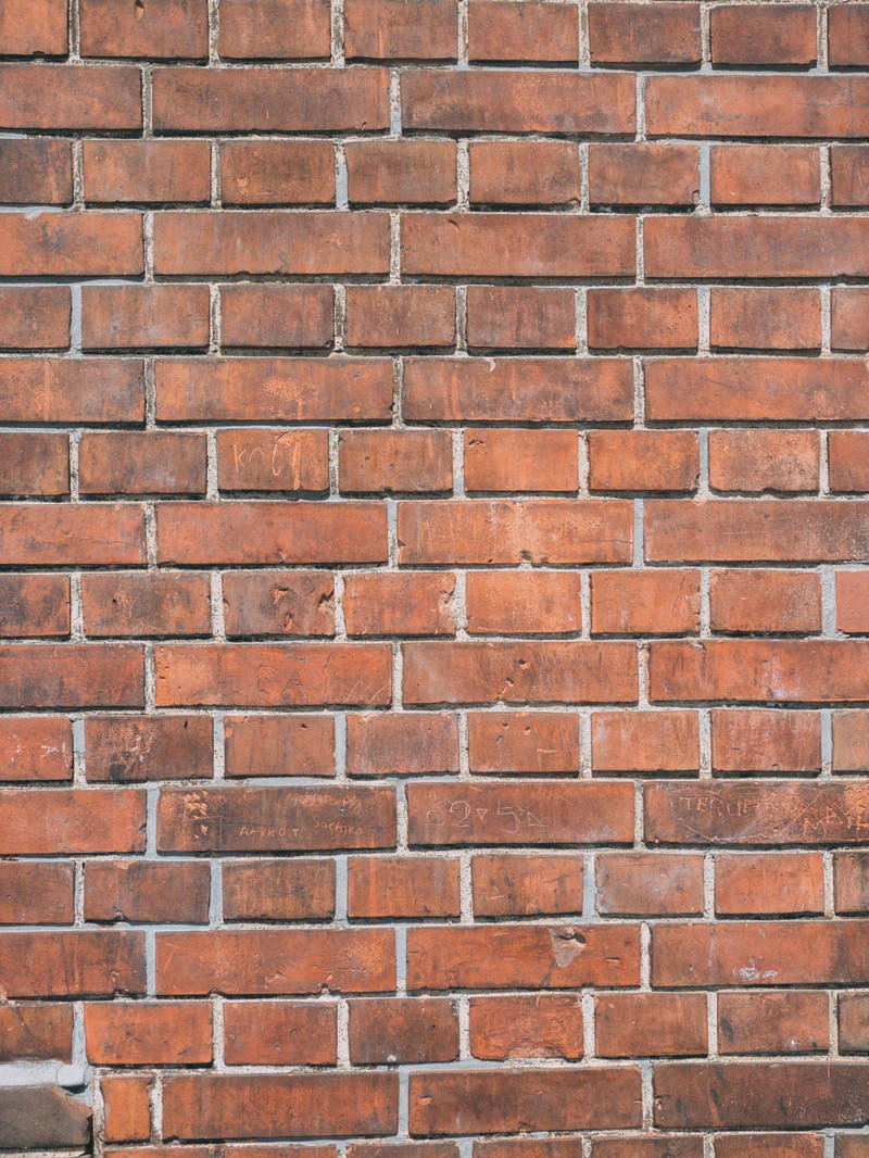 規則正しく積み上げられた赤茶色のレンガ壁のテクスチャー