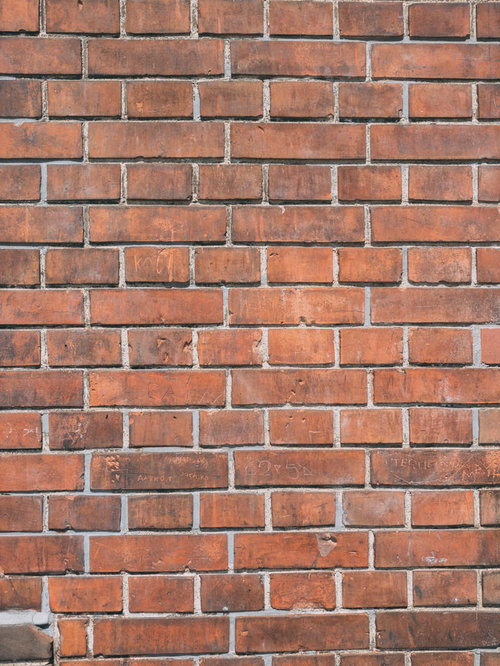 赤レンガの壁に描かれた落書きのテクスチャー