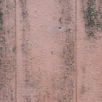 ピンクがかったコンクリート壁に付着した汚れと縦縞模様の写真