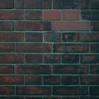 黒く汚れた赤茶色のレンガ壁のテクスチャーの写真