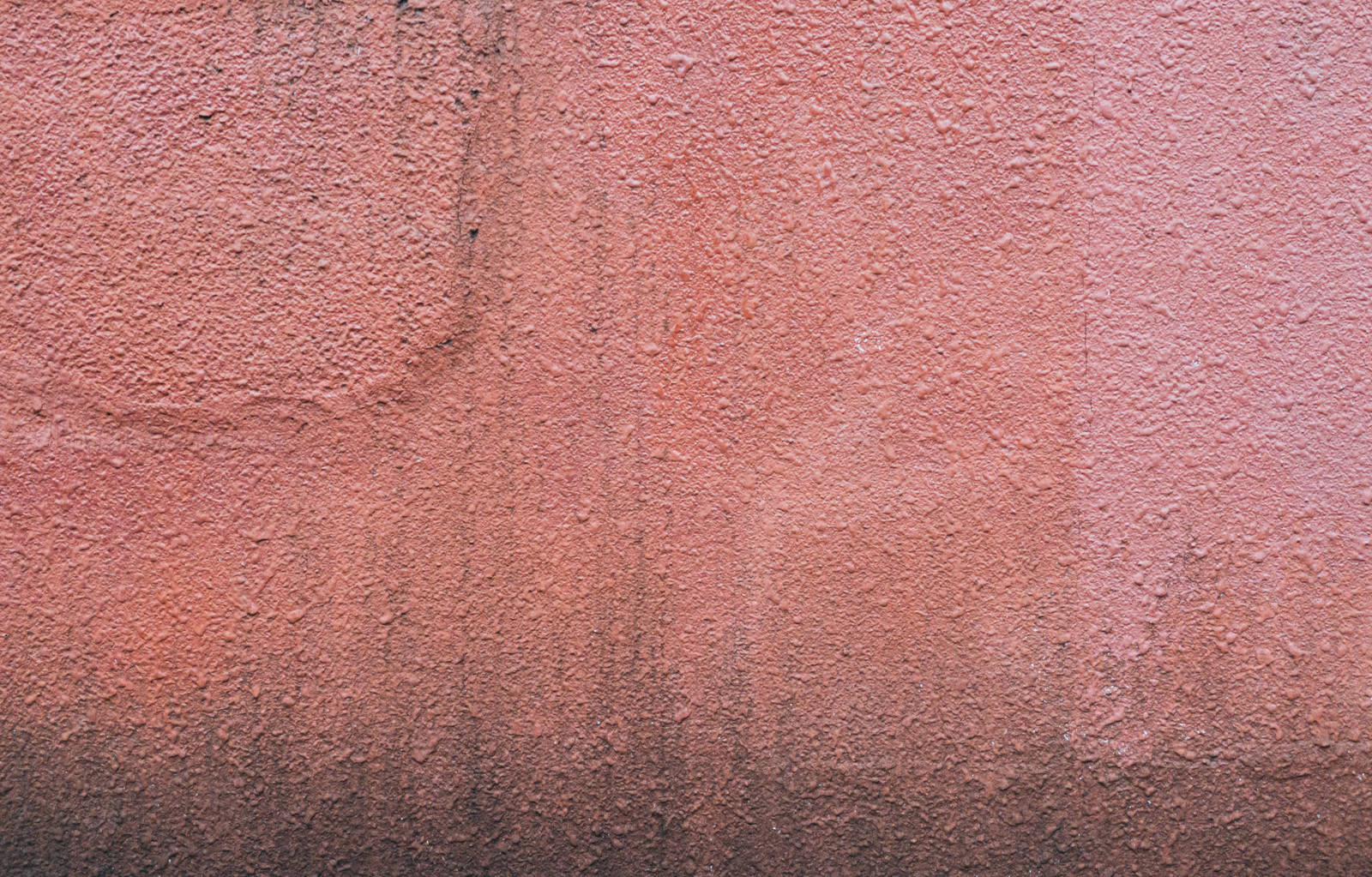 ピンク色のコンクリート外壁に汚れやシミが付いたテクスチャー