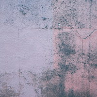 ピンクと白のペイントが剥がれたヒビ割れした壁の写真