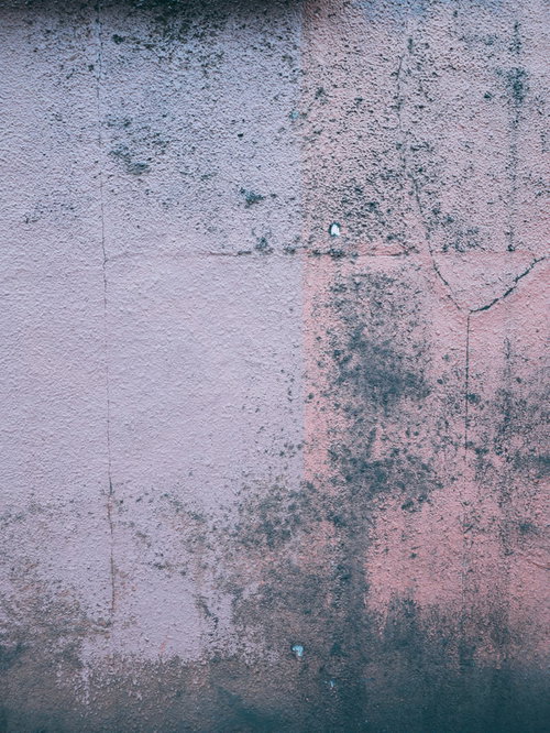 ピンクと白のペイントが剥がれたヒビ割れした壁