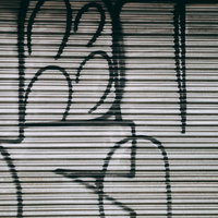 金属製シャッターに描かれた白い落書きとグラフィティの写真