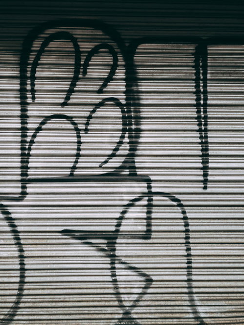 金属製シャッターに描かれた白い落書きとグラフィティ