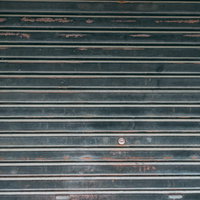 塗装が剥げて錆びたシャッターの表面の写真