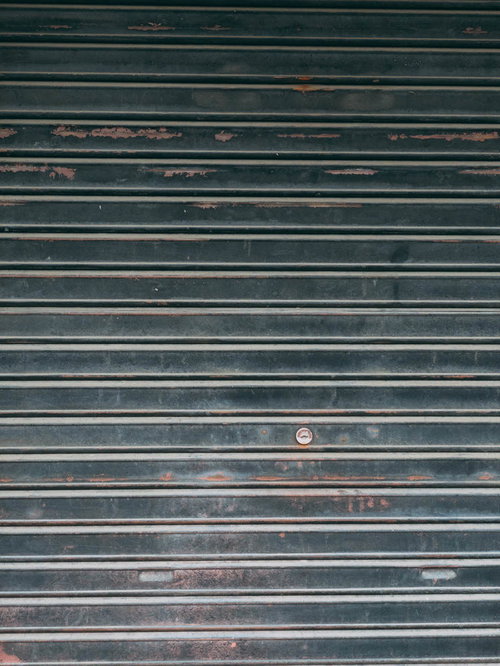 塗装が剥げて錆びたシャッターの表面