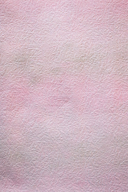 シワの入ったピンク色の紙のテクスチャー背景