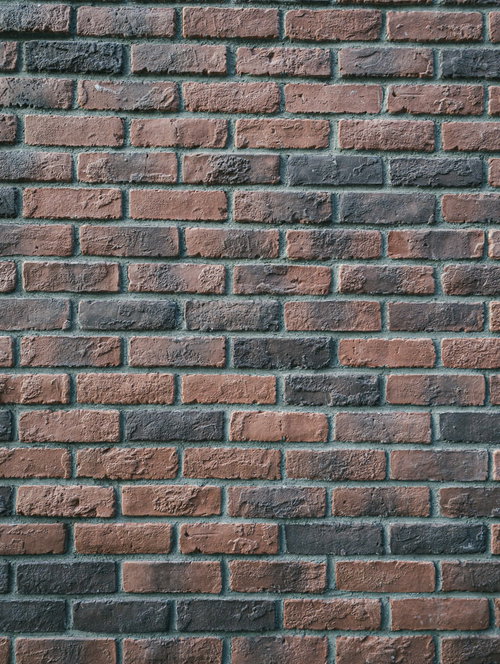 雨風を受けて角が丸くなったレンガ壁のテクスチャー