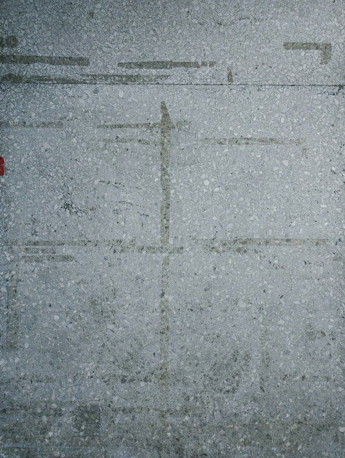 シール跡が残るグレーのコンクリート壁の表面テクスチャー