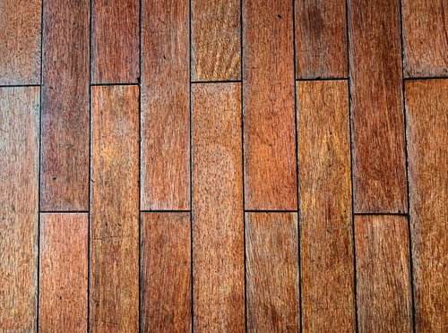 すり減った木目調のタイルの床面、茶色系の使い込まれた質感