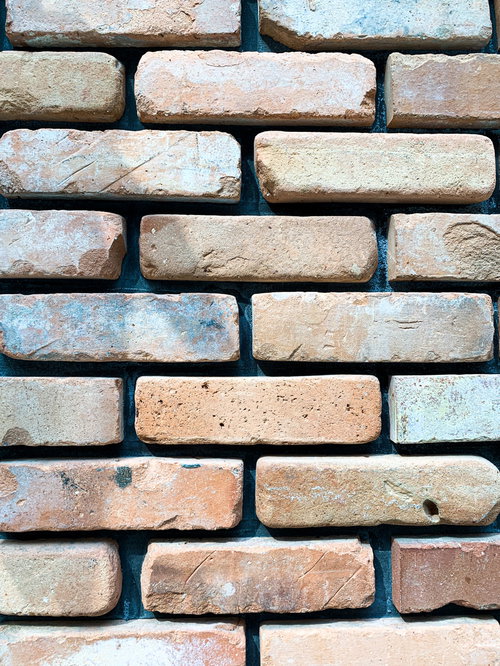 赤茶色の荒削りレンガが積み上げられた壁のテクスチャー