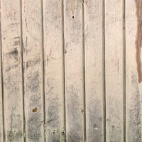 風化によりペンキが褪せた古い板壁の写真