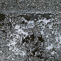 雨上がりの路面に溜まる水のテクスチャーの写真