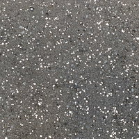 白い粒が散らばるアスファルト路面のテクスチャーの写真