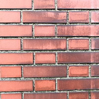 溝の黒ずみが目立つ赤レンガのテクスチャーの写真