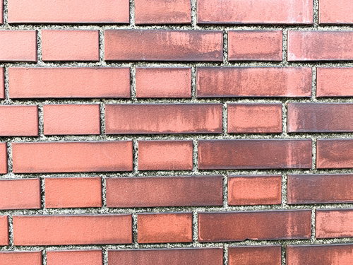 溝の黒ずみが目立つ赤レンガのテクスチャー