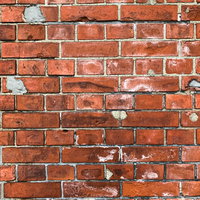 劣化の激しい赤レンガ壁のテクスチャーの写真