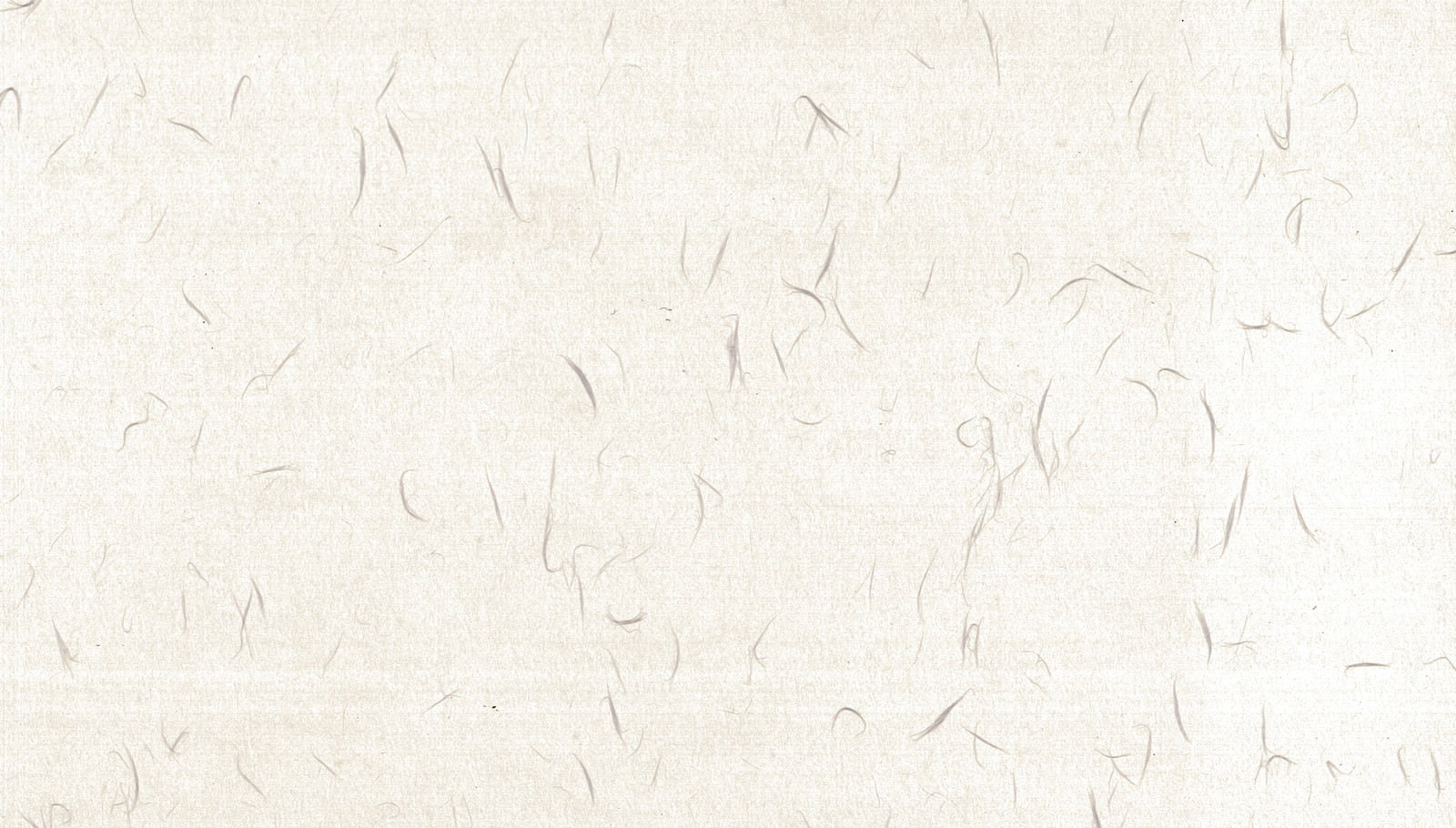 草の繊維が混じったクリーム色の和紙のテクスチャー