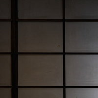 薄暗い室内に配置された格子状の障子と和風建築の写真
