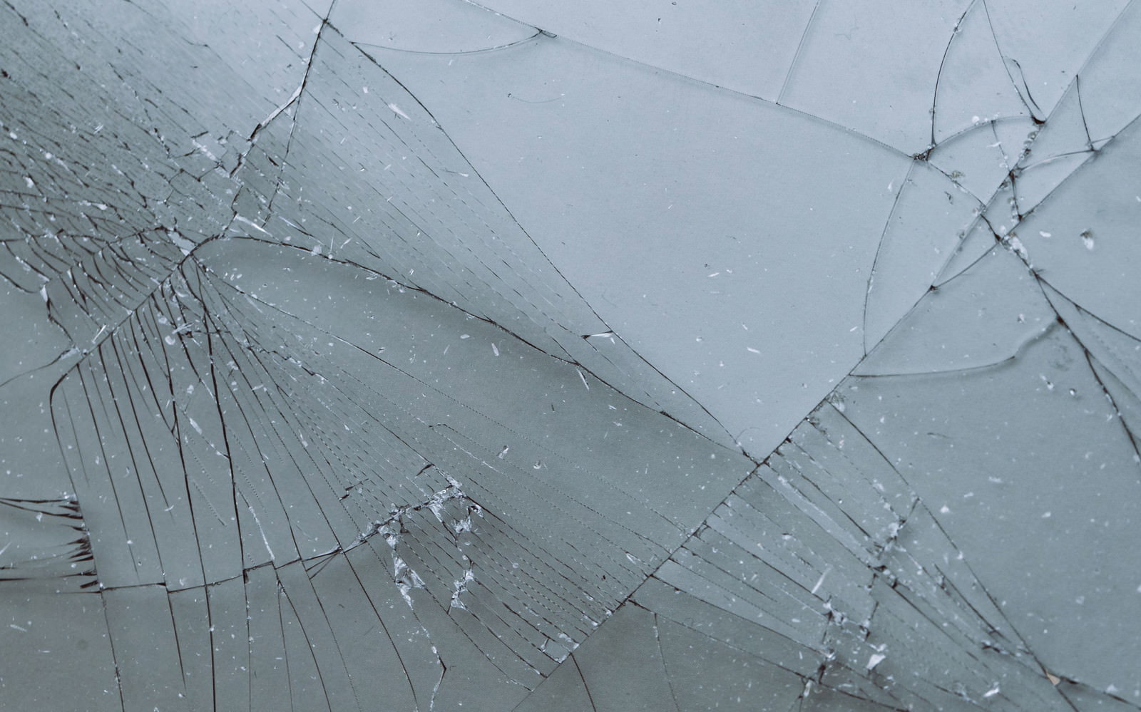 透明なガラス表面に放射状のひび割れが広がるテクスチャー