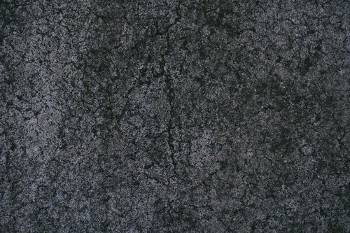 ひび割れしたグレーのコンクリート地面のテクスチャ