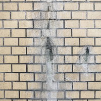 雨水で腐食したベージュ色のタイル壁の劣化テクスチャーの写真