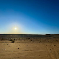 トルクメニスタンの広大な砂漠地帯に昇る太陽の写真