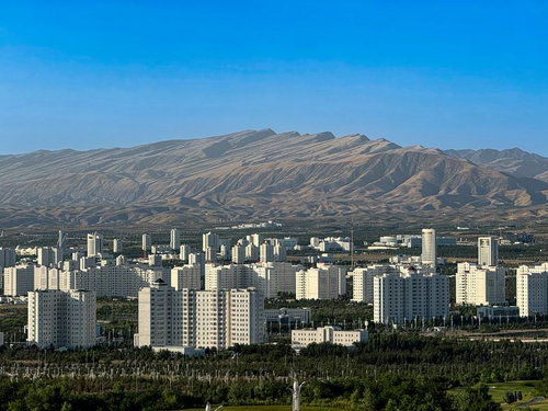 首都アシガバートの白牙の都市と背後の砂漠山脈