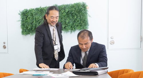 やっぱりデータよりも紙でしょ、と資料を確認する管理職の男性たち