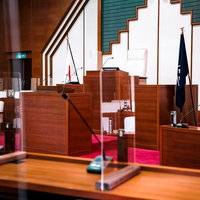 新型コロナ対策のアクリル板で仕切られた議会の議員席の写真