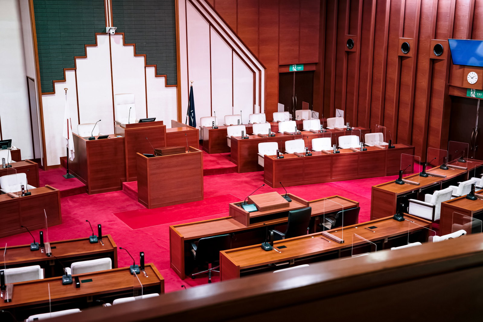 赤絨毯が敷かれた津山市議会の議場。木製議席が並び、議長席と演壇が配置されている
